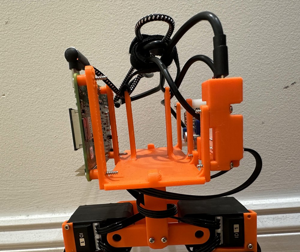 The front of the hip platform, an orange printed frame with vertical posts and the battery compartment in the center.